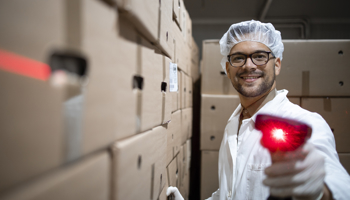 Factory worker with hairnet holding bar code scanner