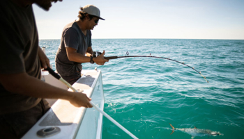 Two people fishing on a commercial fishing charter
